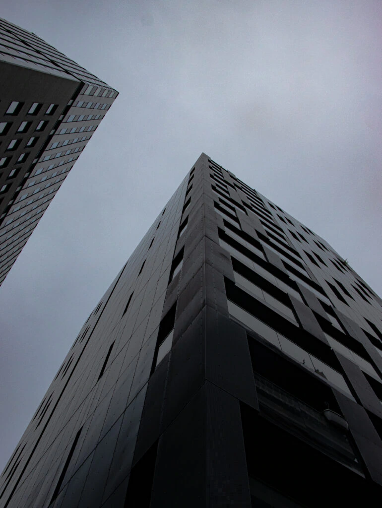 Buildings photographed from below against a grey sky
