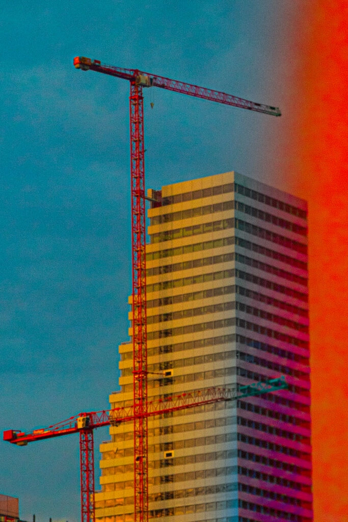 A crane and building facade with a colourful treatment