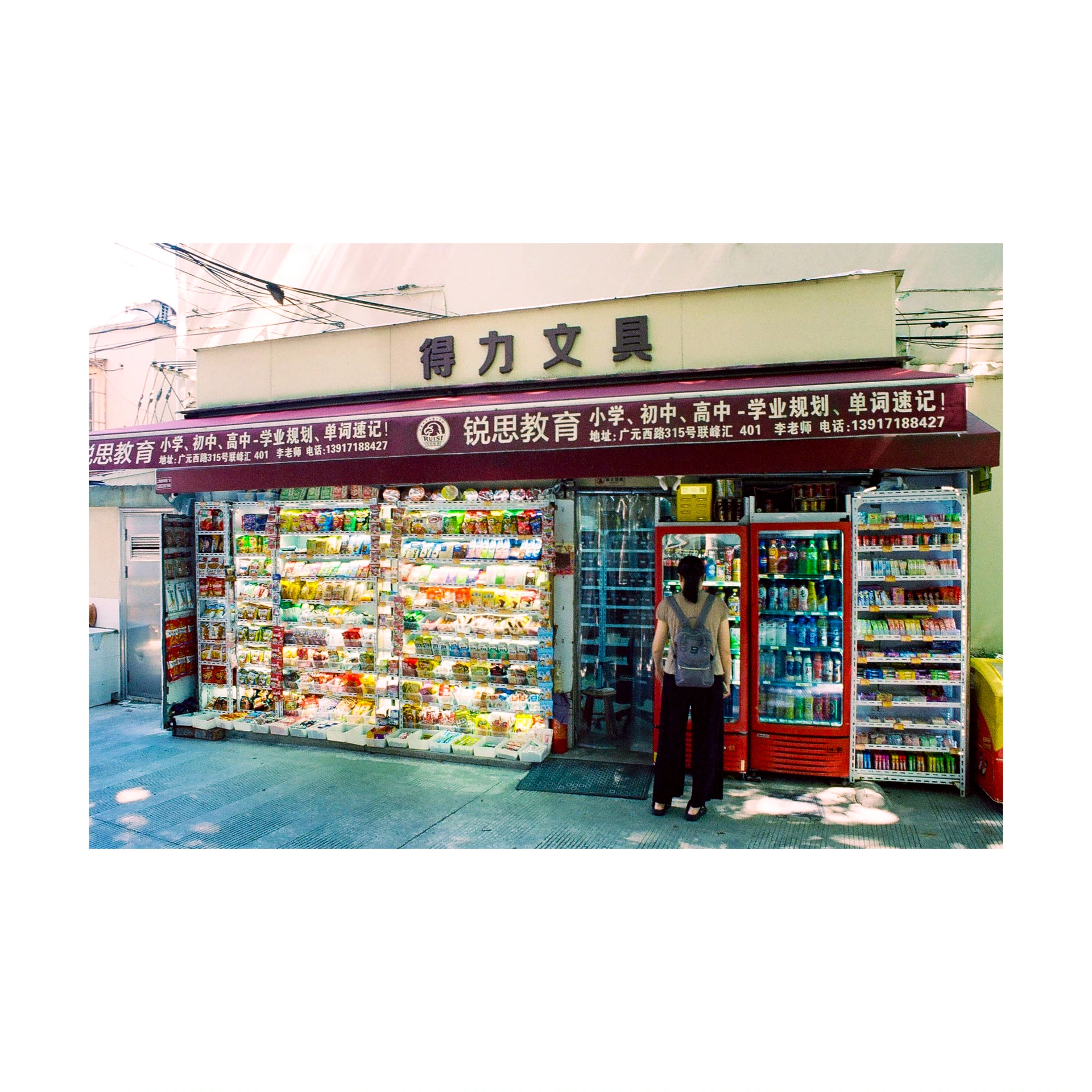 Person outside a stationery shop with colourful displays in China