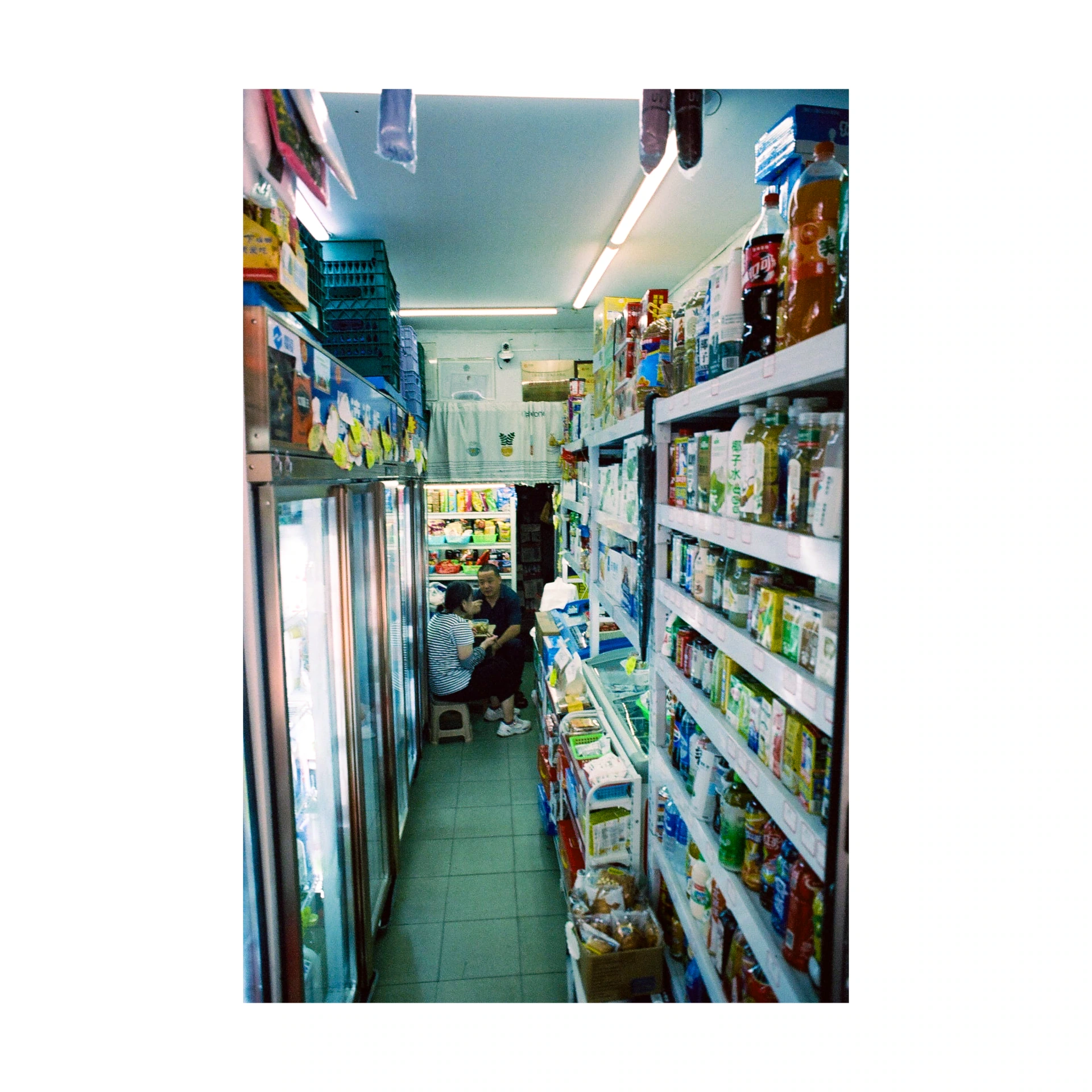 Narrow aisle between stocked shelves in a shop