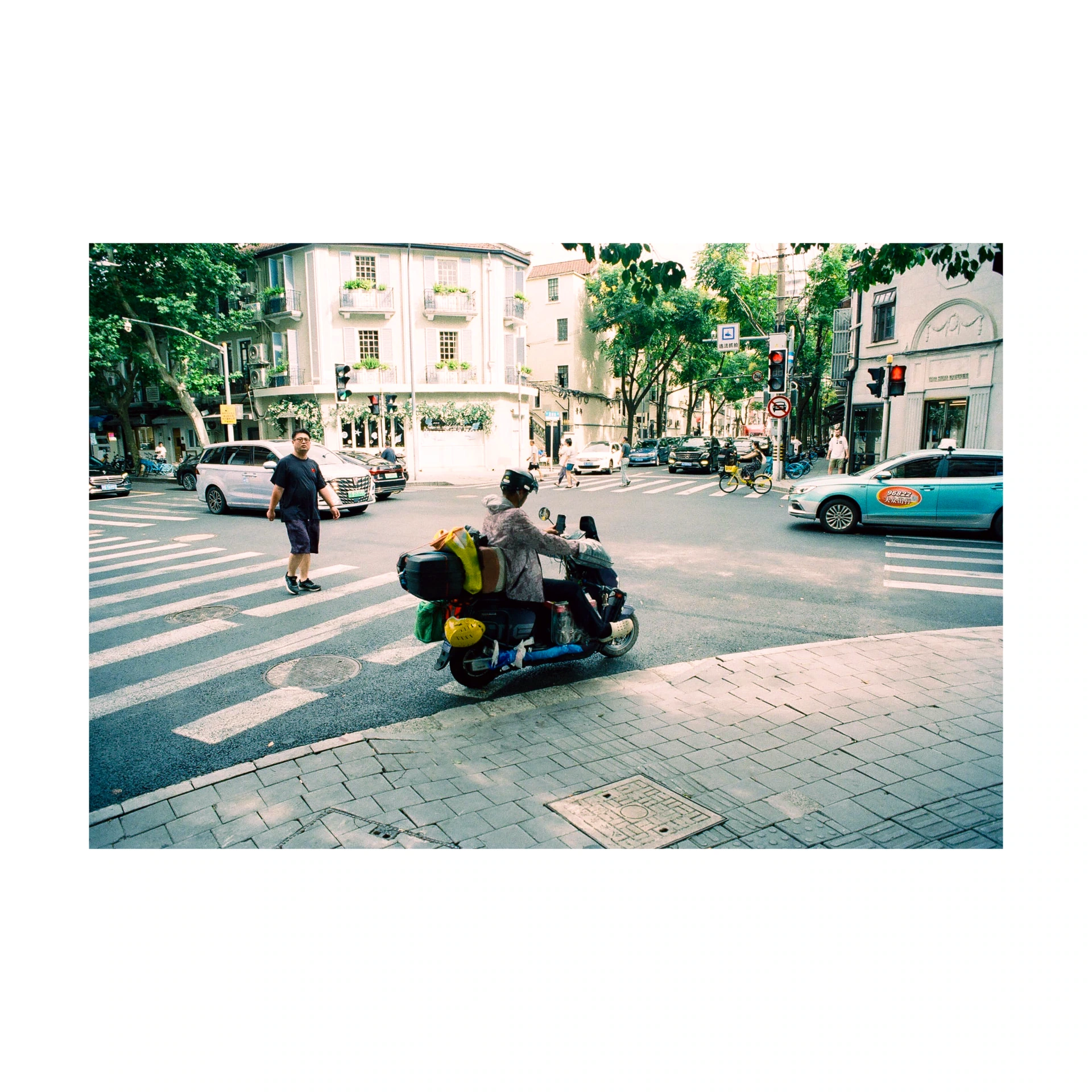 Scooter and pedestrians at a crossing on a street in China
