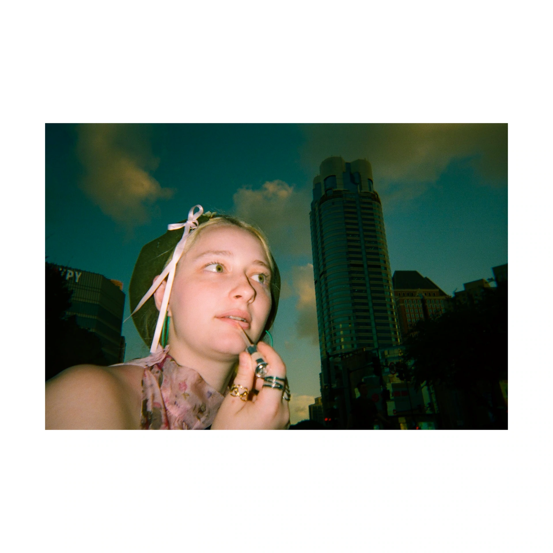 Flash portrait of a person in front of buildings at night