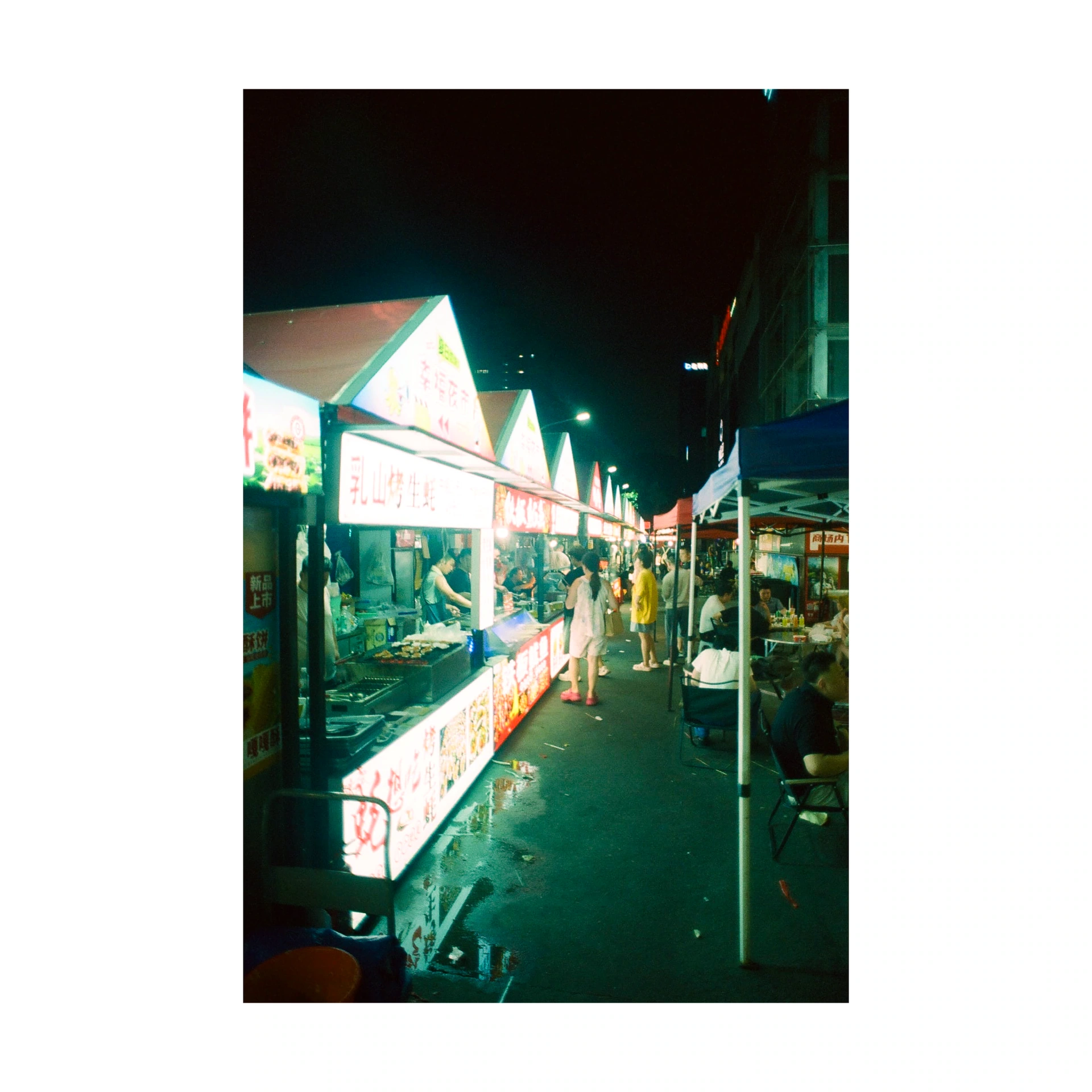 Night market aisle lined with illuminated stalls