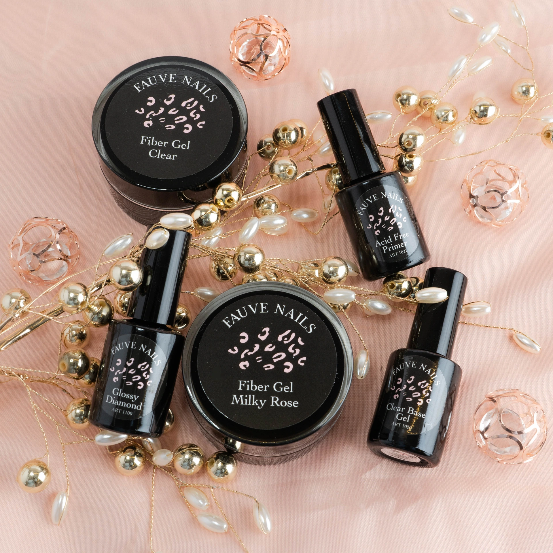 Produits Fauve Nails avec perles et fleurs sur fond rose