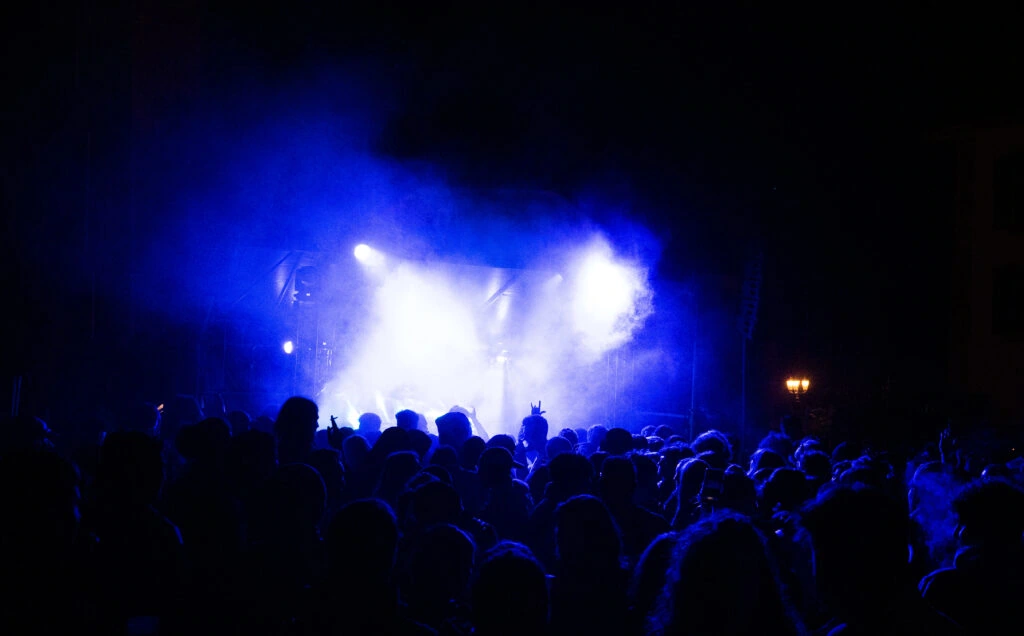 A concert crowd beneath blue stage lights