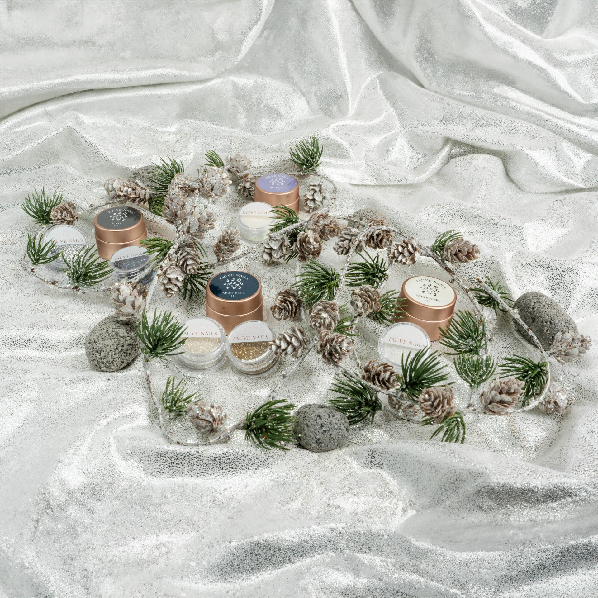 Fauve Nails products in a winter arrangement on silver fabric