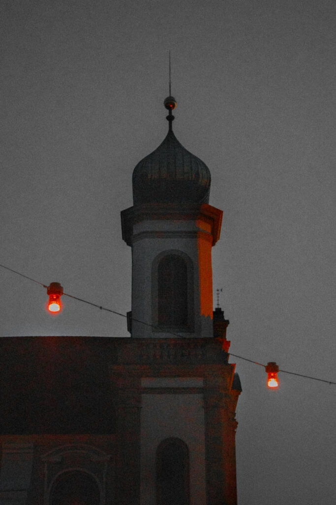 A tower at dusk with hanging red lanterns