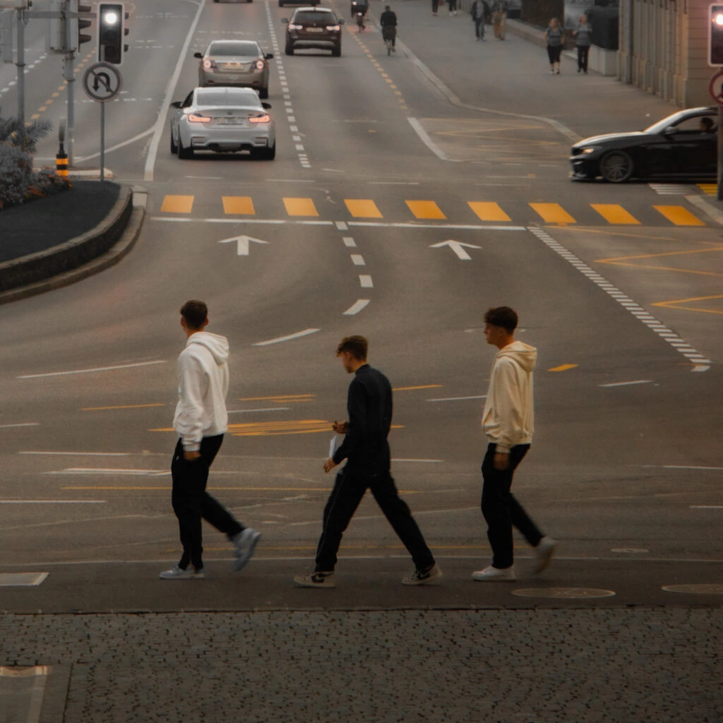 Three pedestrians crossing a street