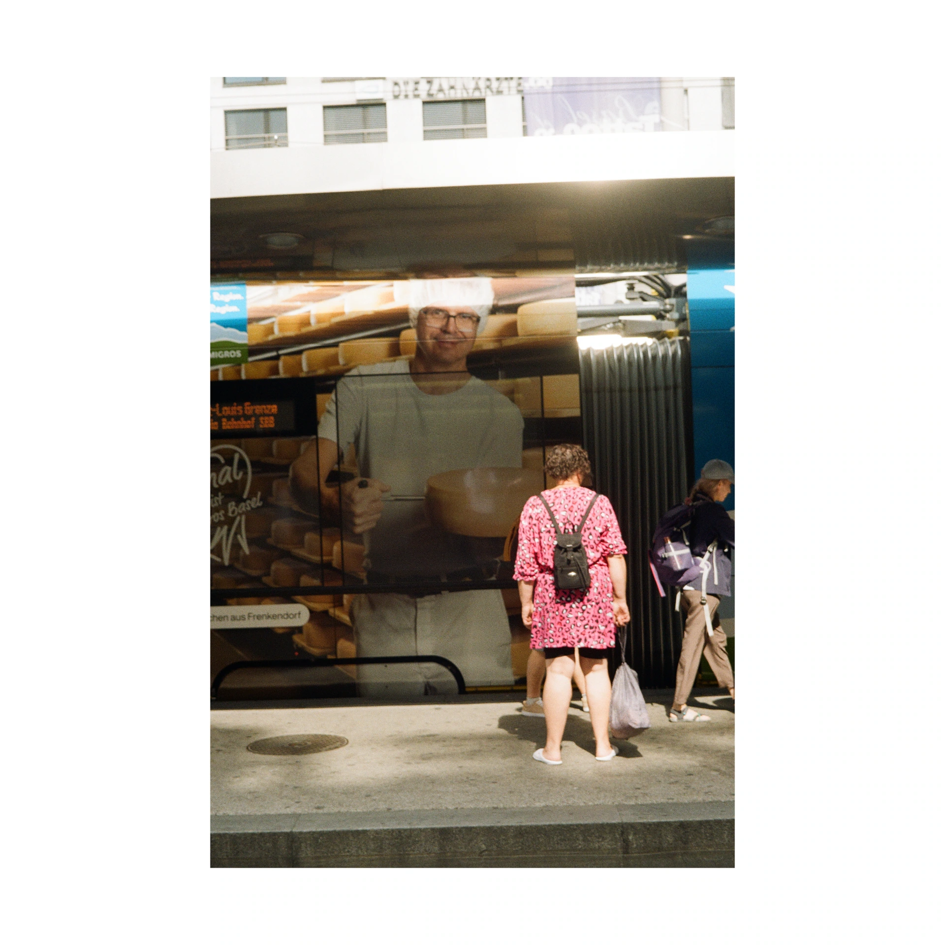 People walking past a large poster on a shopping street