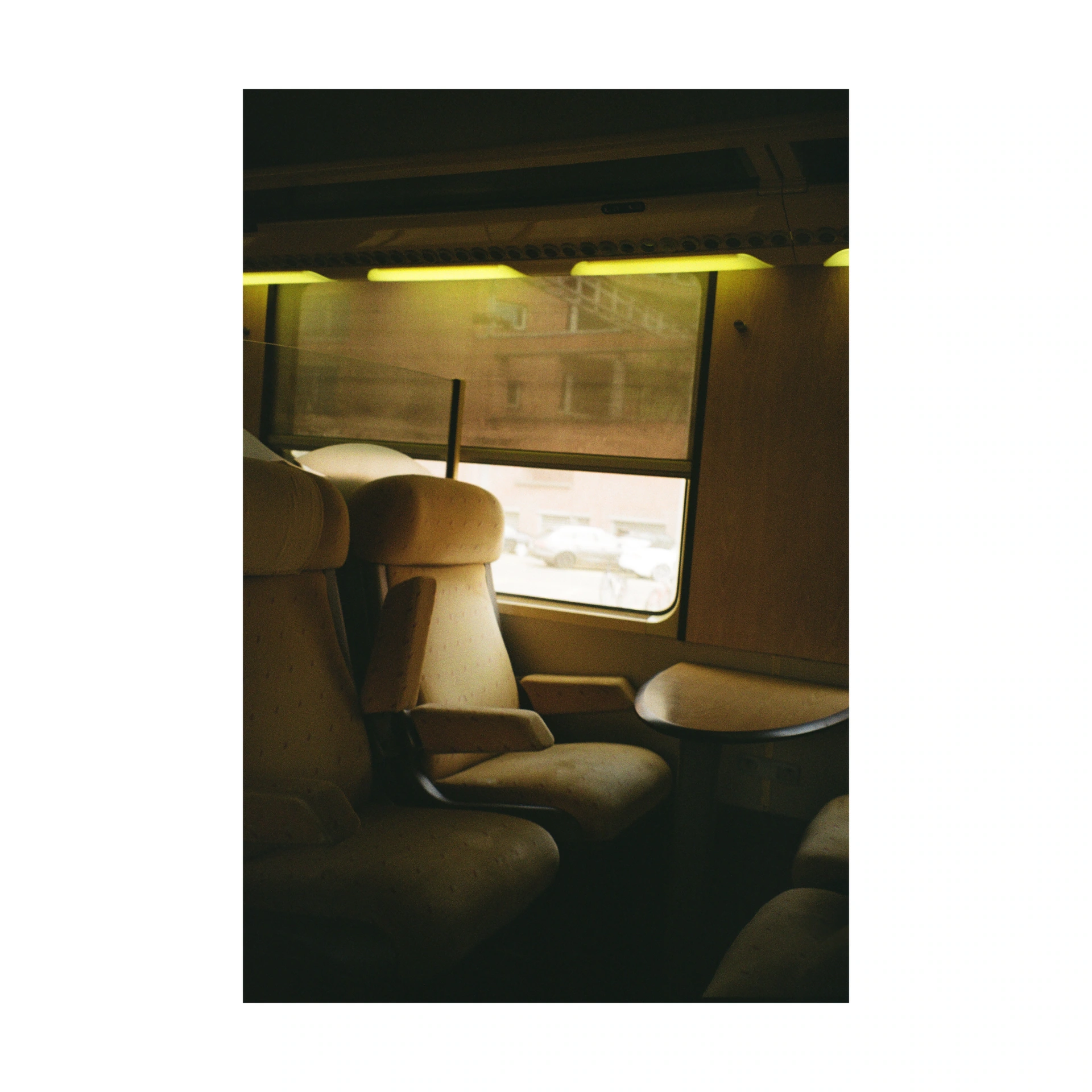 Seats and window in a train compartment in warm light
